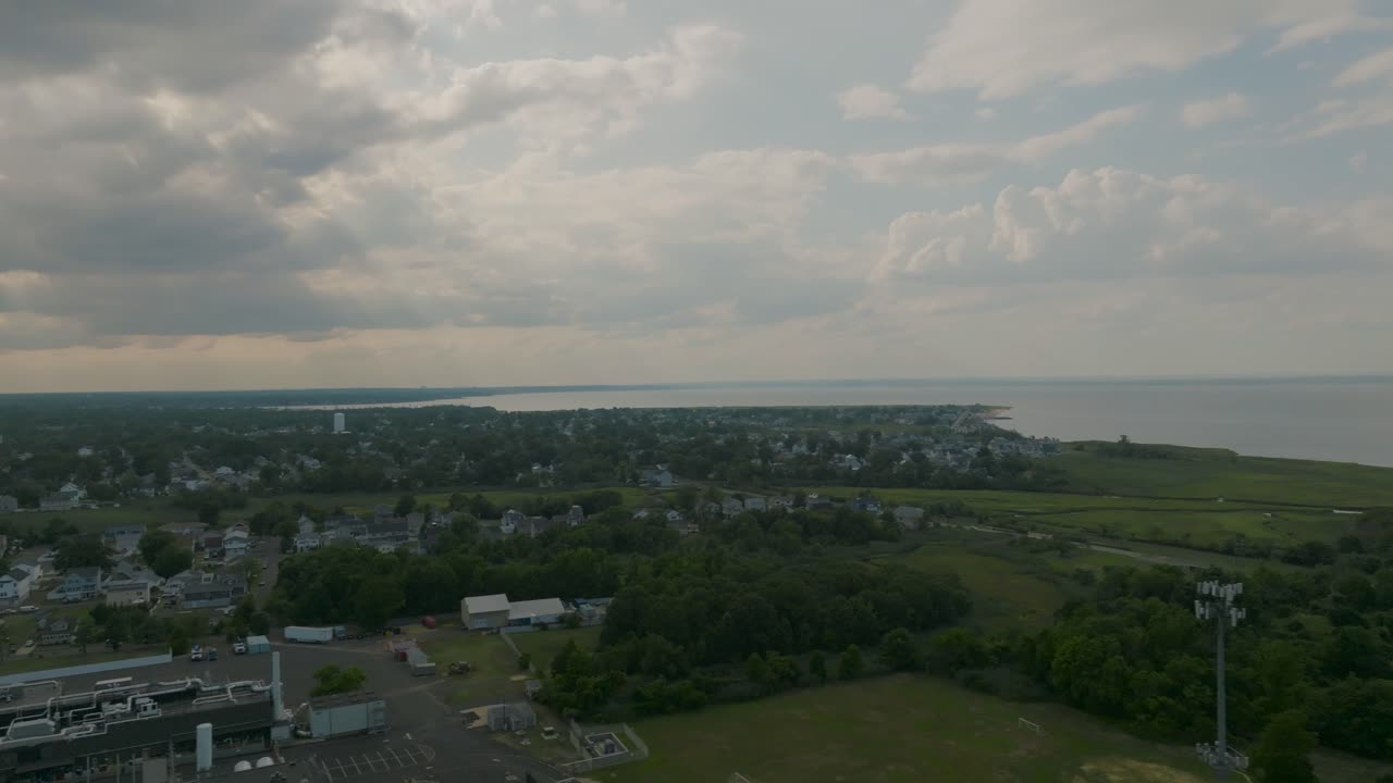 Stunning aerial drone footage of a New Jersey coastline with sunlight streaming across the sky and water