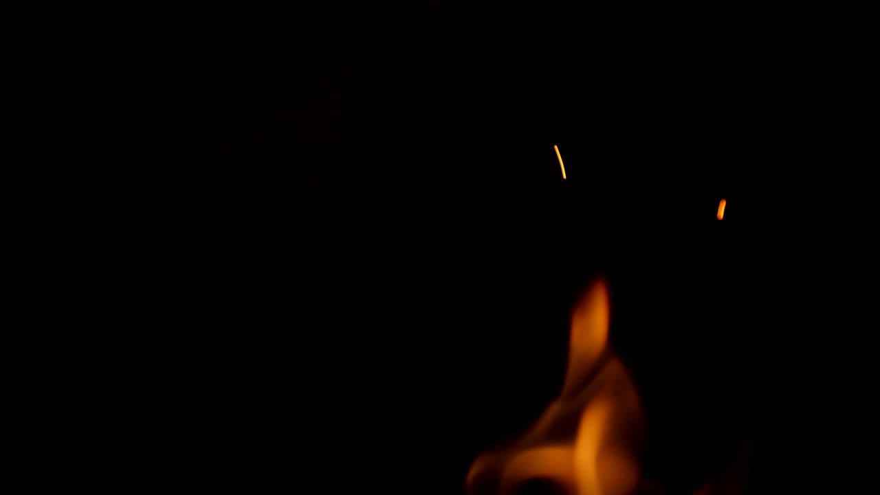 Sparkling, flying up sparkles for using in composition, vertical on black backdrop isolated. Screen mode for blending or transitions. Bright flames of fire on studio background, slow motion 50 fps 4k