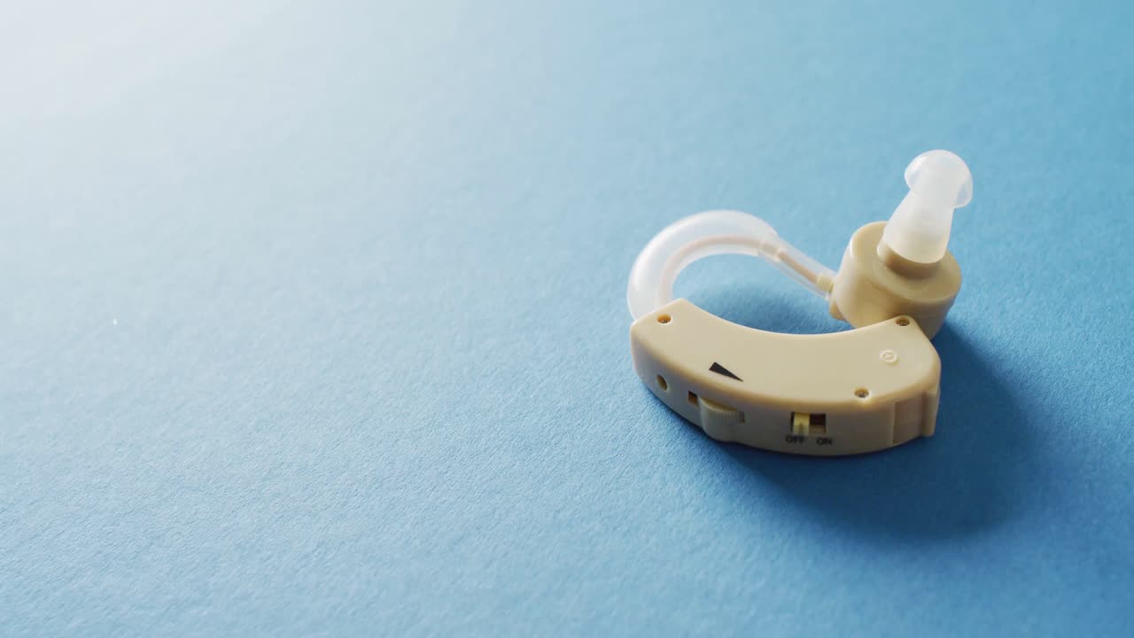 Video of hearing aid on blue background with copy space