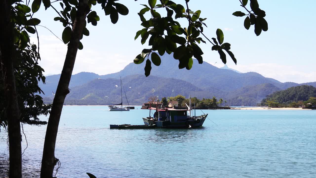 viejo barco de pesca de madera con pájaros volando alrededor en un hermoso fondo de montaña