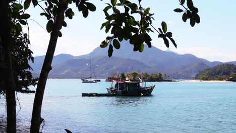 old wooden fishing boat with birds flying around in a beautiful mountain background