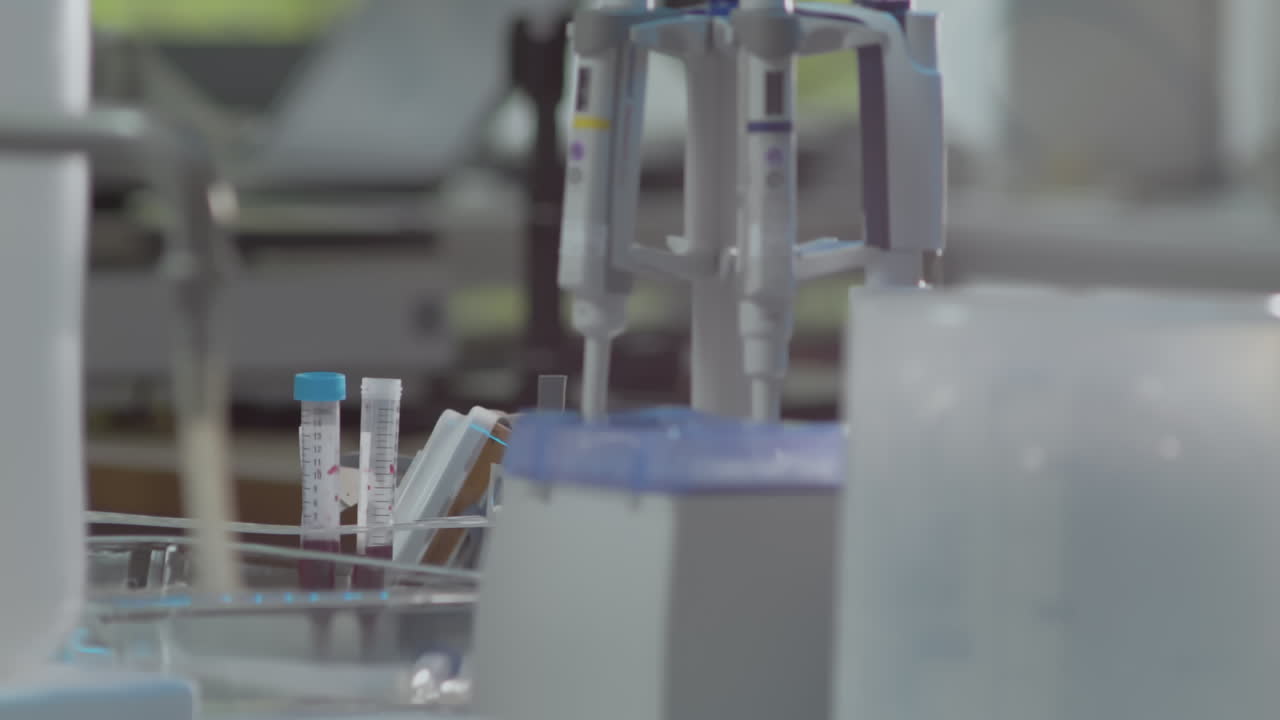 Test tubes with blood and pipettes in laboratory, workspace lab shot panning left
