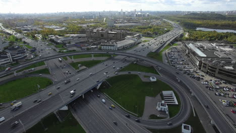 Zeitraffer-Aus-Der-Luft-Einer-Geschäftigen-Metropole-Mit-Verkehr-Am-Autobahnkreuz