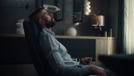professional stock exchange broker sitting in chair with eyes closed, relaxing after work and successful trading day. investment agent in modern home office or financial agency office. dolly shot.