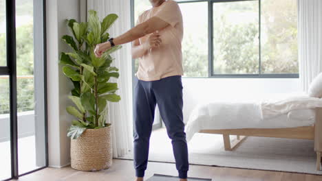 Senior-biracial-man-exercising,-practicing-yoga-at-home