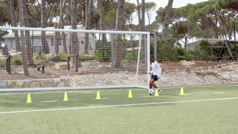 young boy practicing soccer skills on field with cones, focused and determined