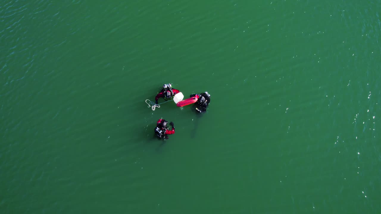 프랑스 남부의 호수에서 물체를 찾고 있는 세 명의 다이버
