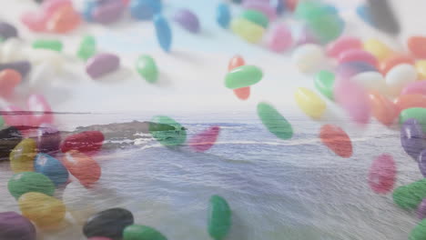 floating colorful jelly beans over ocean waves and rocky shoreline animation