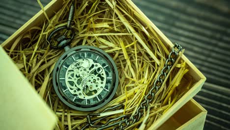 el reloj de bolsillo de lapso de tiempo se enrosca en paja de trigo natural en una caja de madera.