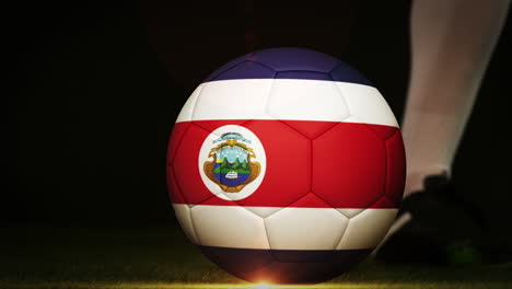 jugador de fútbol pateando la pelota de la bandera de costa rica