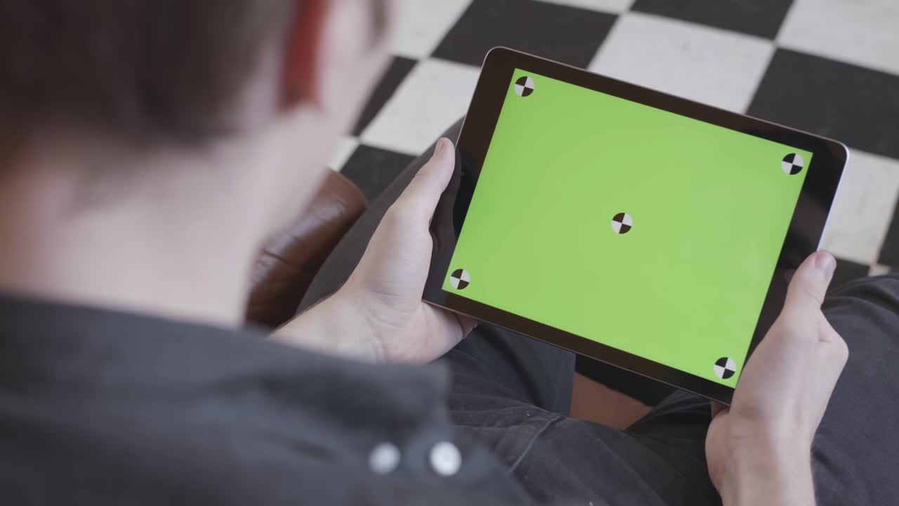 녹색 화면 을 가진 태블릿 을 들고 있는 사람