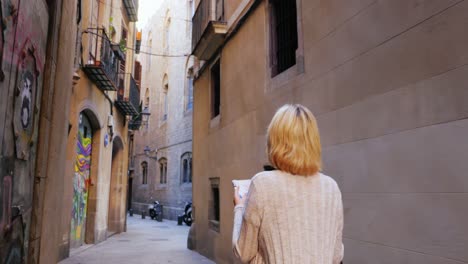 A-woman-with-a-map-in-her-hands-walks-through-the-narrow-streets-of-the-Gothic-quarter-in-Barcelona-2