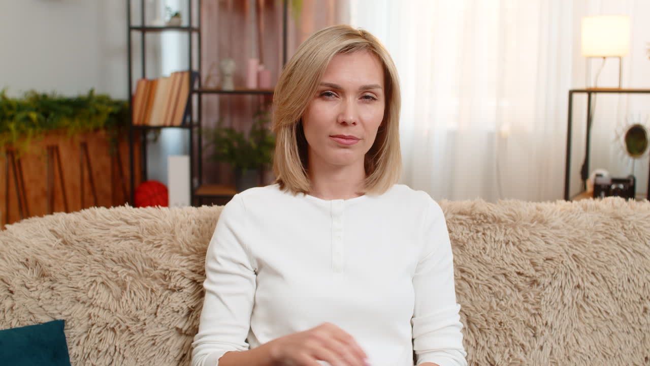 Adult woman gesturing money waste at home expressing frustration about spending or expensive prices