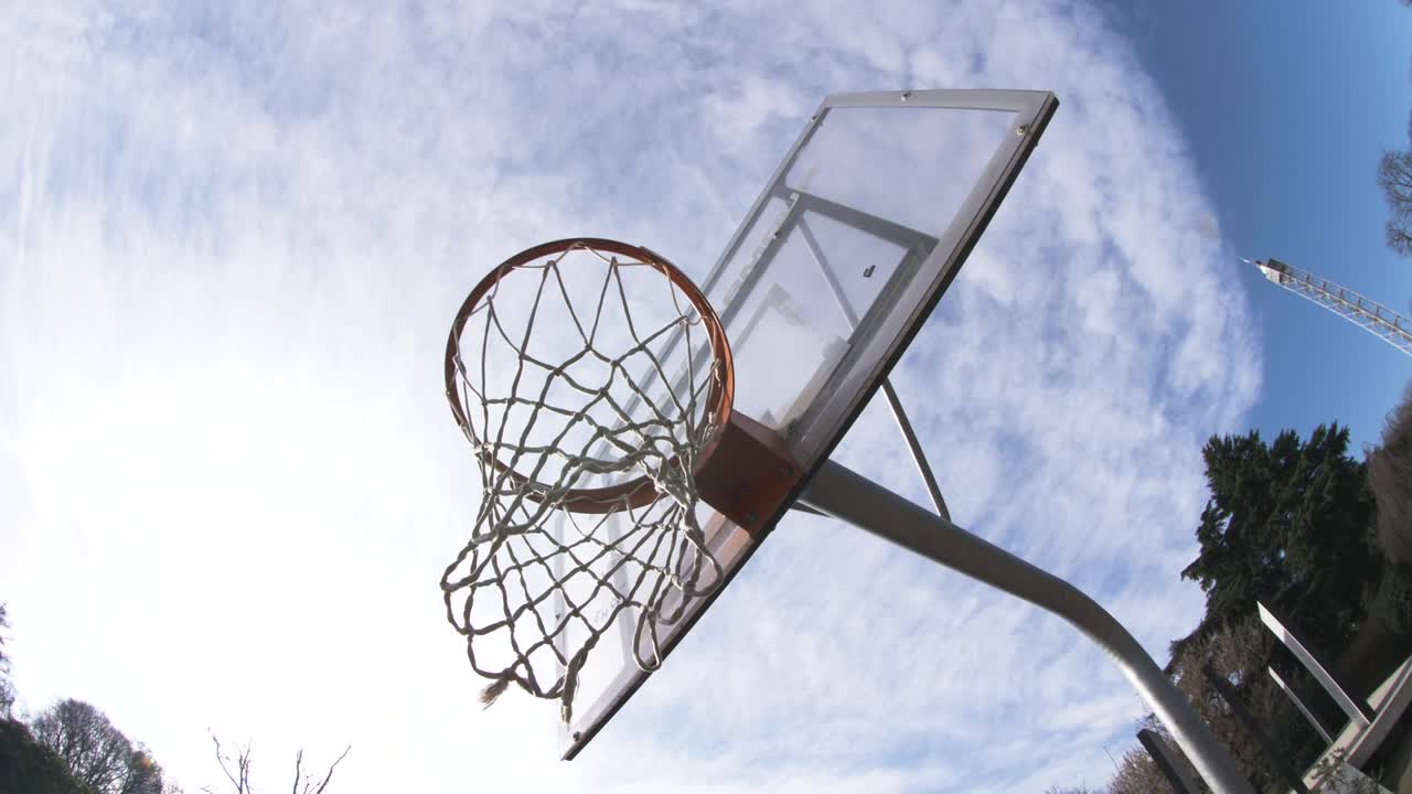 야외 놀이터에서 네트와 함께 농구 바구니. 카메라가 주위를 움직입니다.