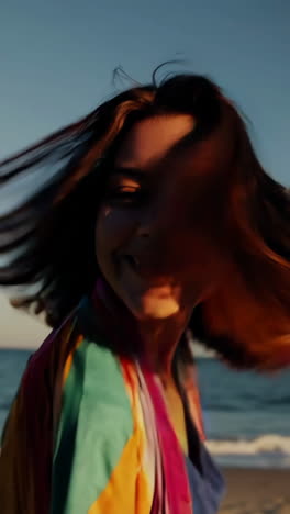 joyful woman with colorful scarf on a beach at sunset