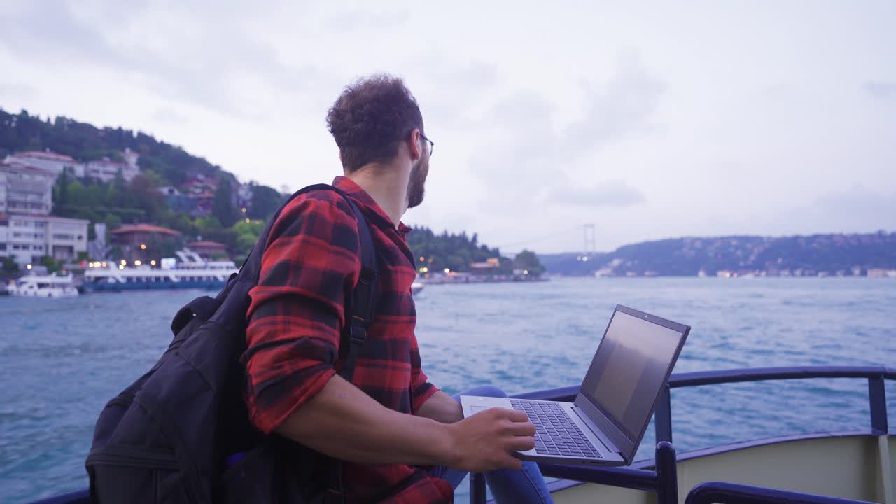 hombre trabajando en una computadora portátil en el ferry.