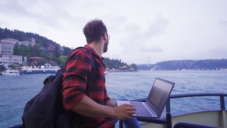 Man-working-on-laptop-on-ferry.