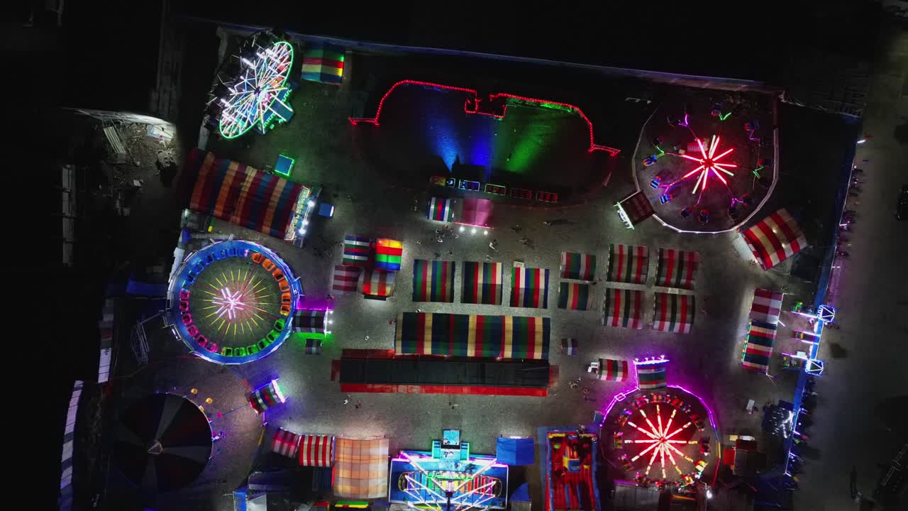 Aerial top-down timelapse of bustling, colorful pop-up carnival at Virac Town Center, Catanduanes, Philippines during nighttime.