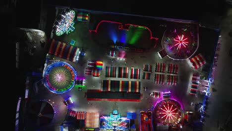 aerial top-down timelapse of bustling, colorful pop-up carnival at virac town center, catanduanes, philippines during nighttime.