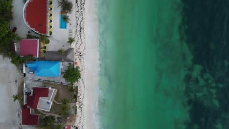 Uroa-beach-resorts-and-homes-in-Zanzibar-Island-Tanzania-Africa,-Aerial-top-view-dolly-up-shot