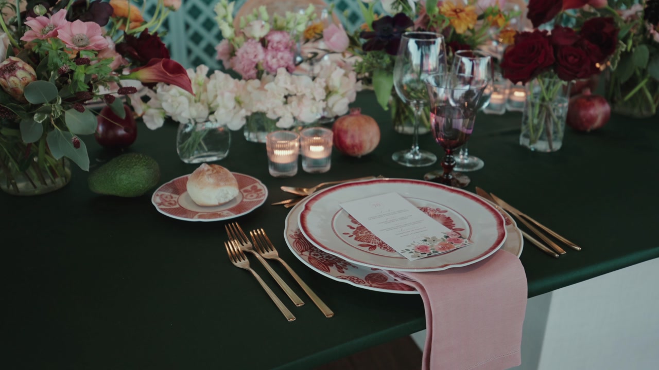 Close up of decorated table setting with plate gold cutlery candles flowers and glassware for wedding reception