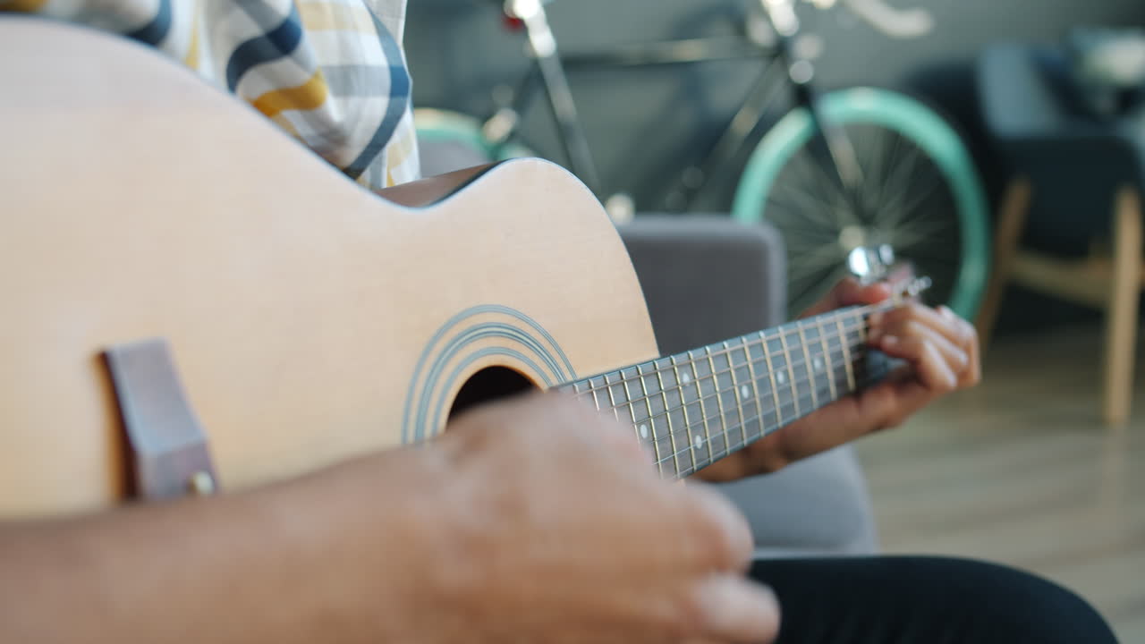 persona que toca la guitarra acústica