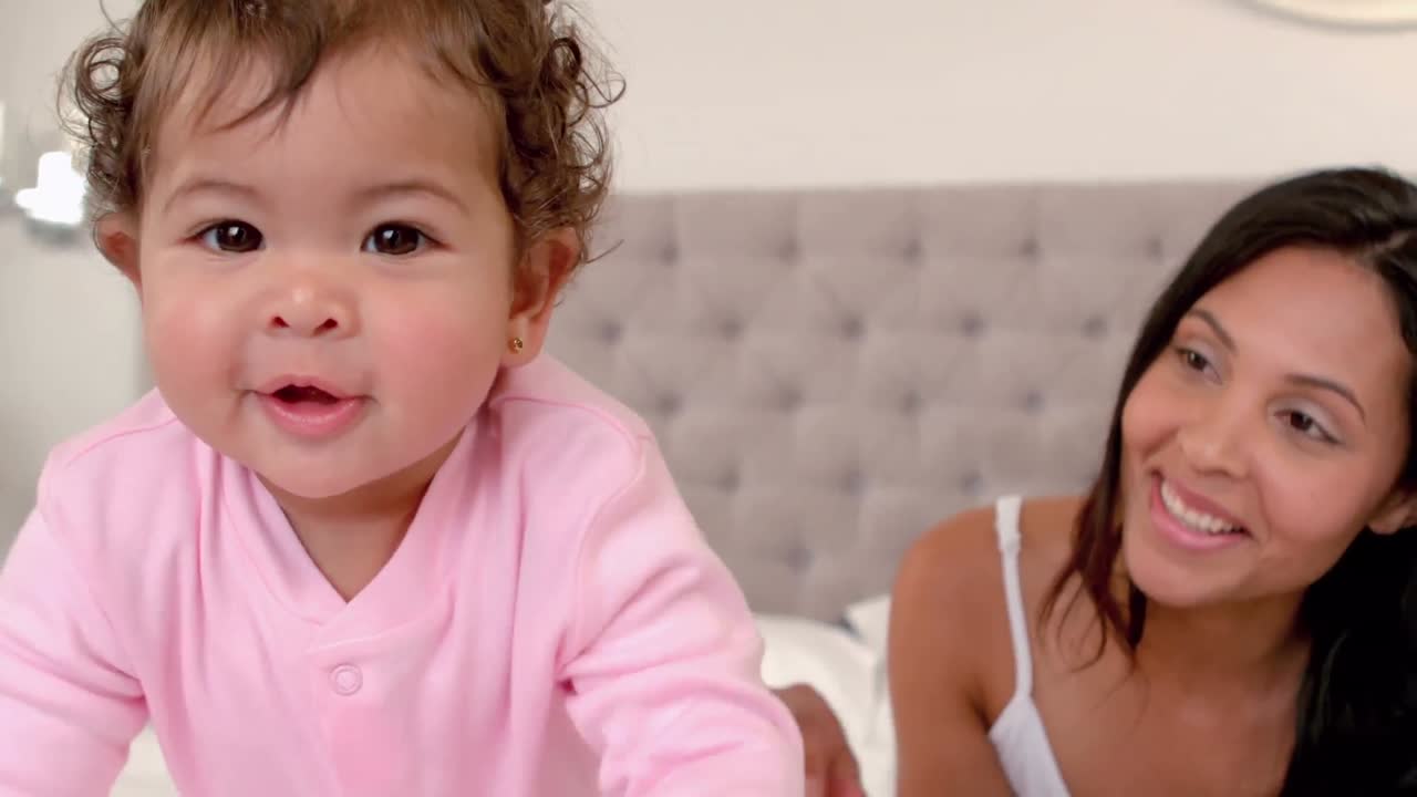 침대에서 아기 딸과 함께 놀고 있는 엄마