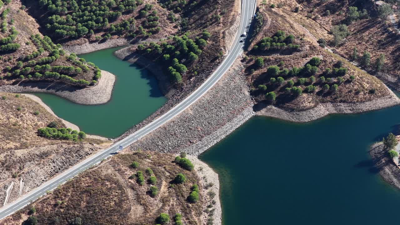 Cars driving on a road near a reservoir with water scarcity