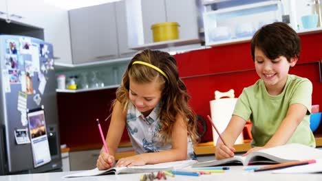siblings doing their homework in kitchen