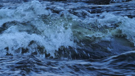 close up footage of fresh flowing turbulent water down a river in northumberland, england on a cold winter's afternoon