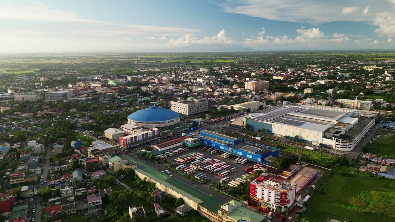 Aerial establishing shot of urban landscape, commercial centers and residential areas amid lush greenery at Naga City, Philippines