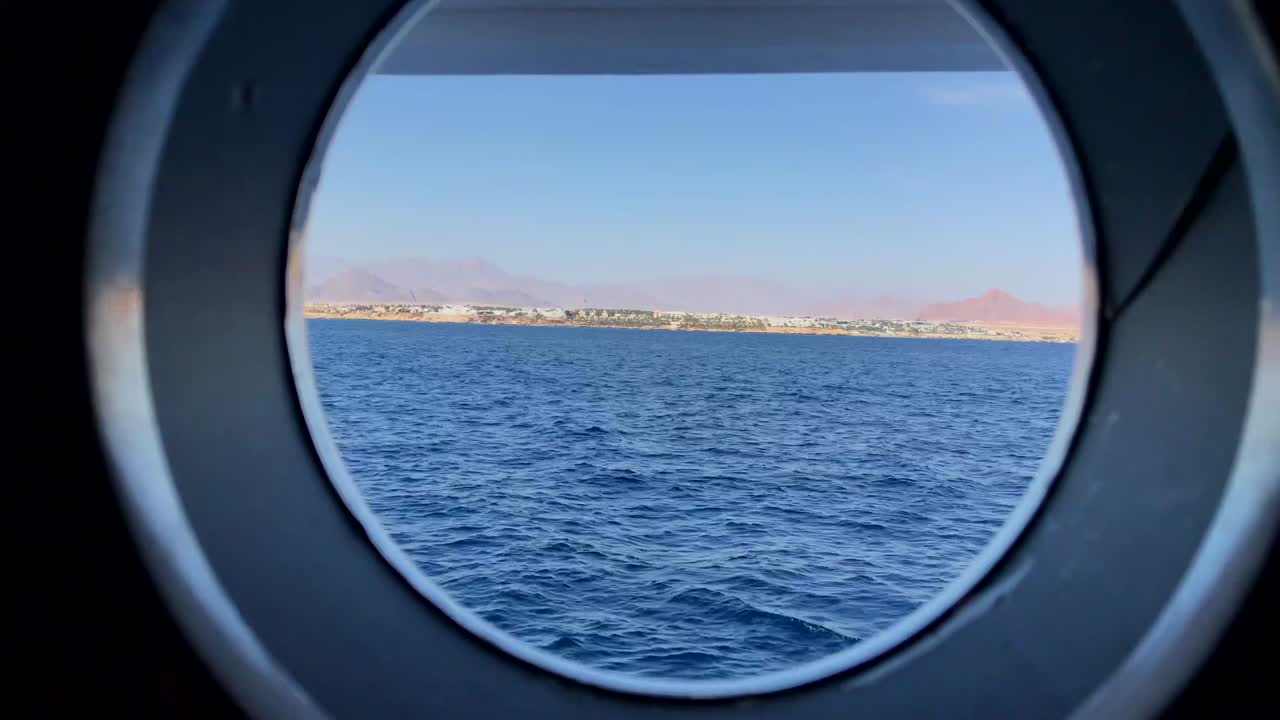 vista desde la ventana de un portillo de un crucero que muestra las montañas de egipto al atardecer