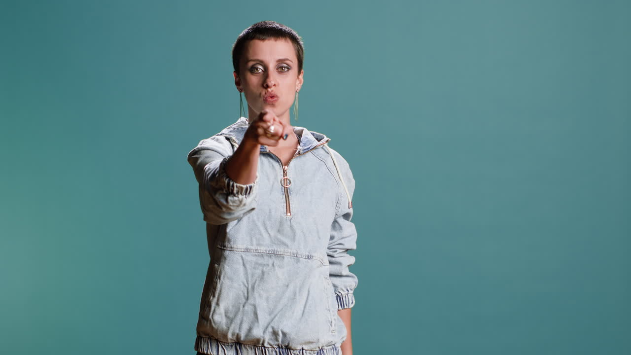 Woman pointing at the camera in a studio shot