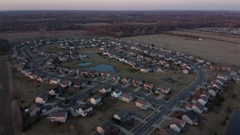 Cozy-private-estate-town-with-water-pond-in-middle,-aerial-drone-view