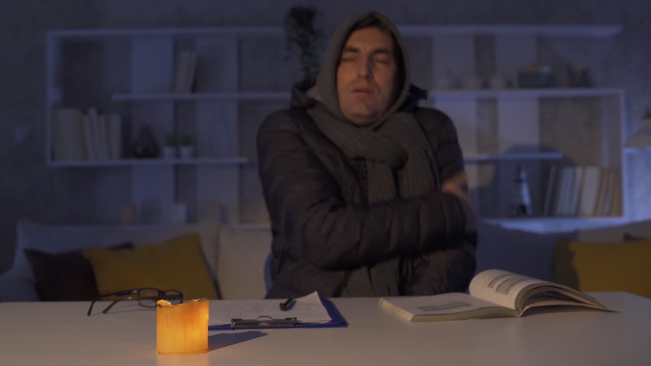 The man shivering from the cold at home.