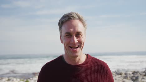 portrait of a caucasian man enjoying free time by sea on sunny day