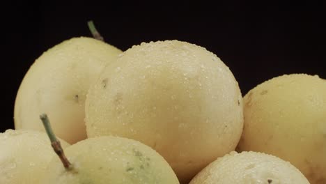 passion fruit closeup with droplets of water dark background