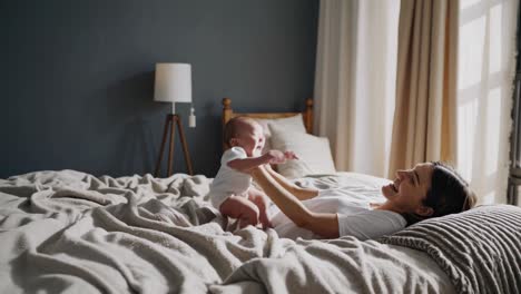 happy mother and baby on bed