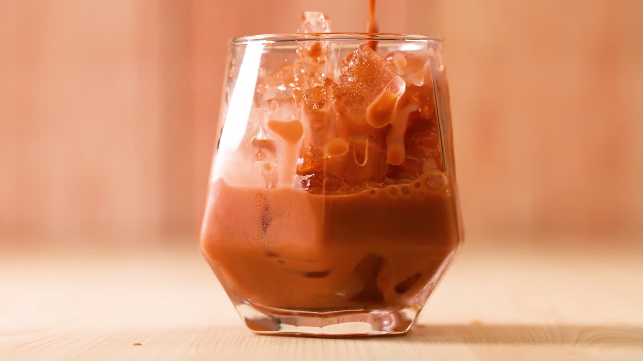 Tè thailandese versato in un bicchiere con ghiaccio