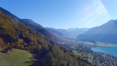 aerial drone view of single home on hill above beautiful lake and alps mountains in brienz switzerland, europe