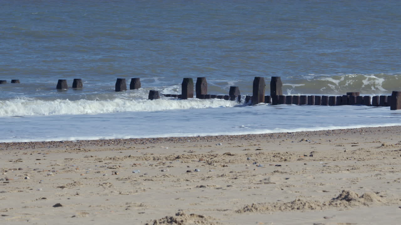 shot of the waves crashing over the sea defence groynes at Walcott Beach