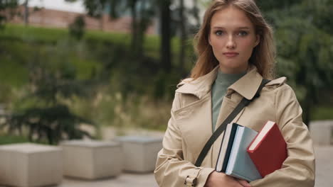 caucasian female student looking at the camera and smiling outdoors.