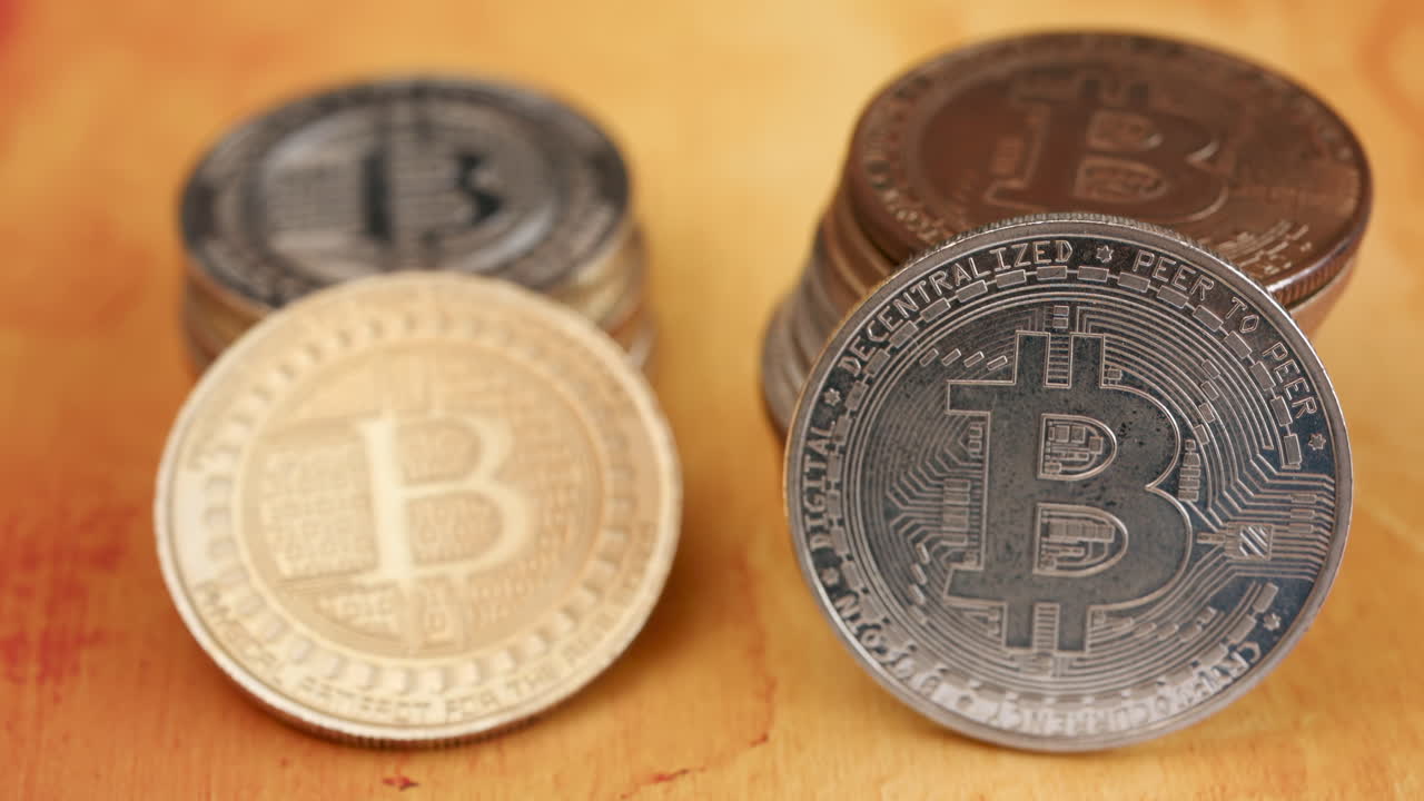 Primo piano di monete Bitcoin fisiche lucide impilate su un tavolo
