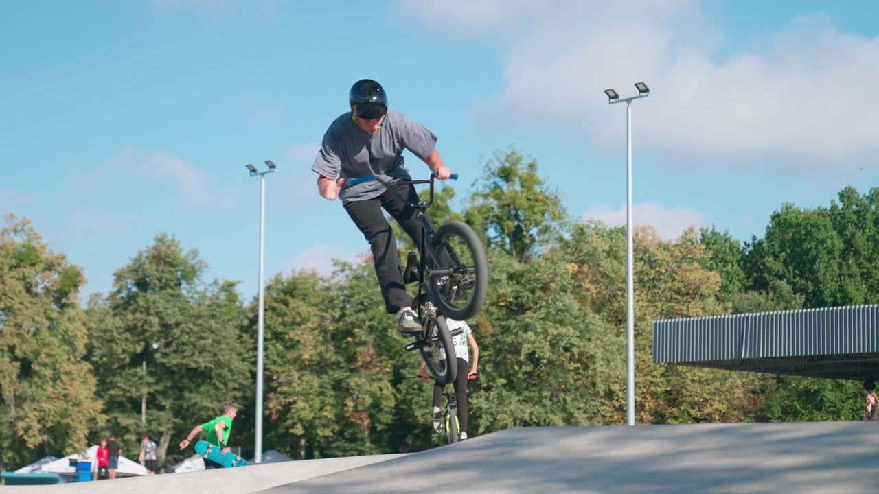 Giovane uomo su una BMX che esegue un salto in uno skatepark