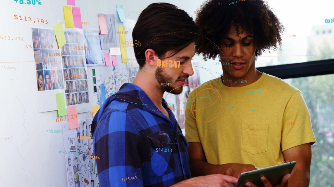 Two male coworkers leaning over tablet left man tapping generating analytics overlays for business