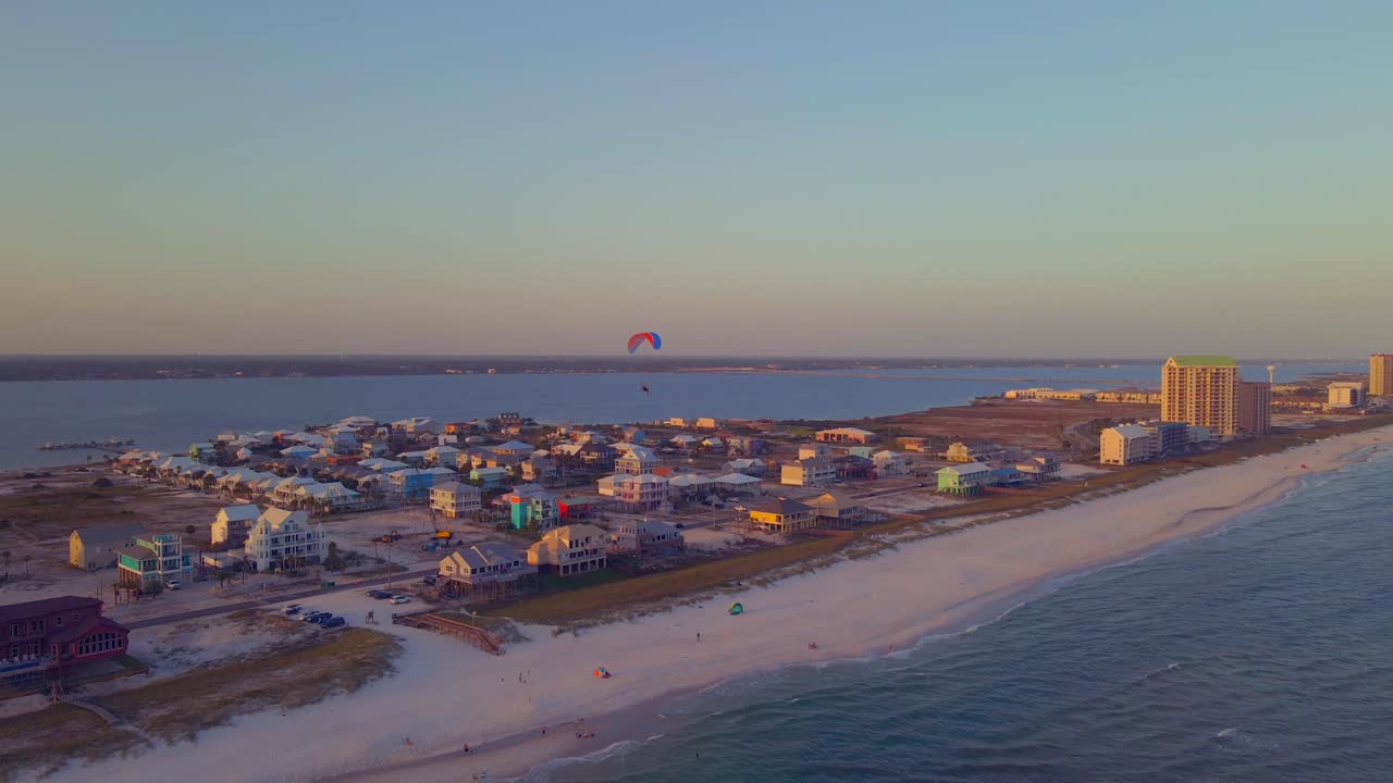 패러글라이더는 해질녘에 바다 위로 하늘을 떠다닌다