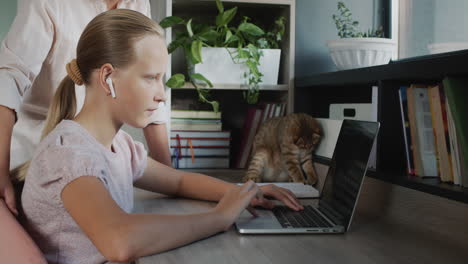 woman helps a teenage girl do her homework. education at home concept