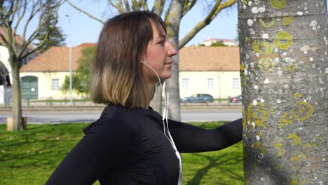 mujer joven deportiva con auriculares haciendo ejercicio en el parque