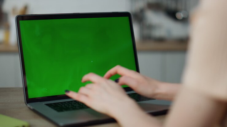 Pige arbejder med en mockup-computer derhjemme, tæt på. Hænder taster på bærbar computers tastatur.