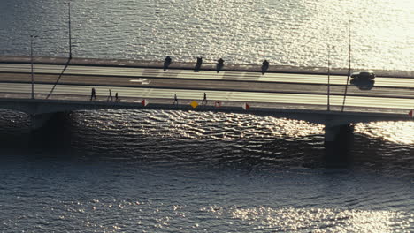 city bridge over river with people walking